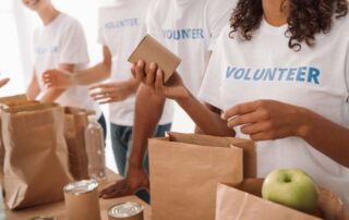 A group of volunteers holding bags of food who are providing support to a proposal for the Federal Government.