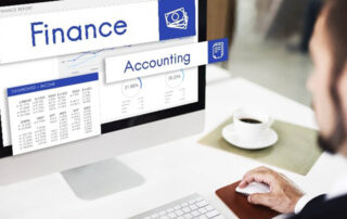 A man working on a computer with the word finance on the screen, providing Proposal Support for the Federal Government.